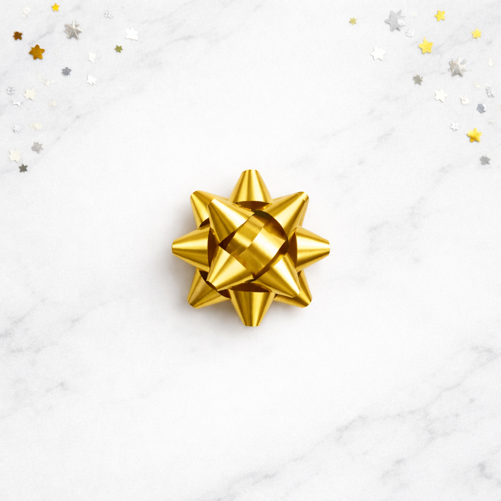 Gold gift bow on a white background with confetti