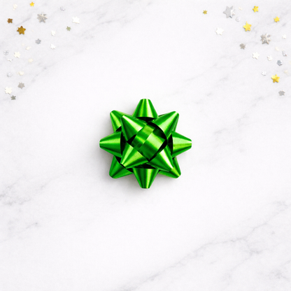 Green gift bow on a white background with star-shaped confetti