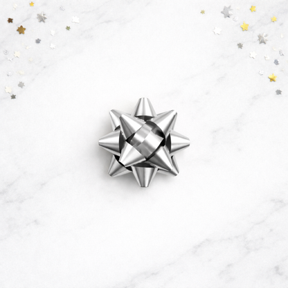 Silver bow on a white background with star-shaped confetti