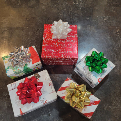 Five Christmas presents with colorful bows on a dark textured surface